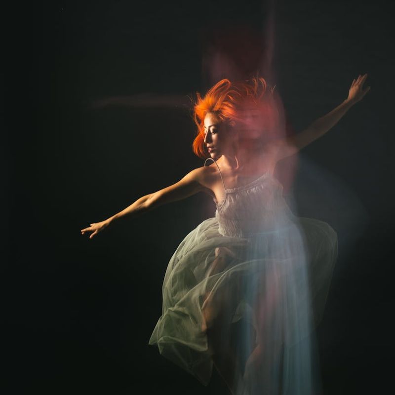 A person in motion, blurred to convey fluidity and grace against a minimalist backdrop.